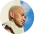 Profile photo of a bald man with a beard looking to the side against a blue sky background.